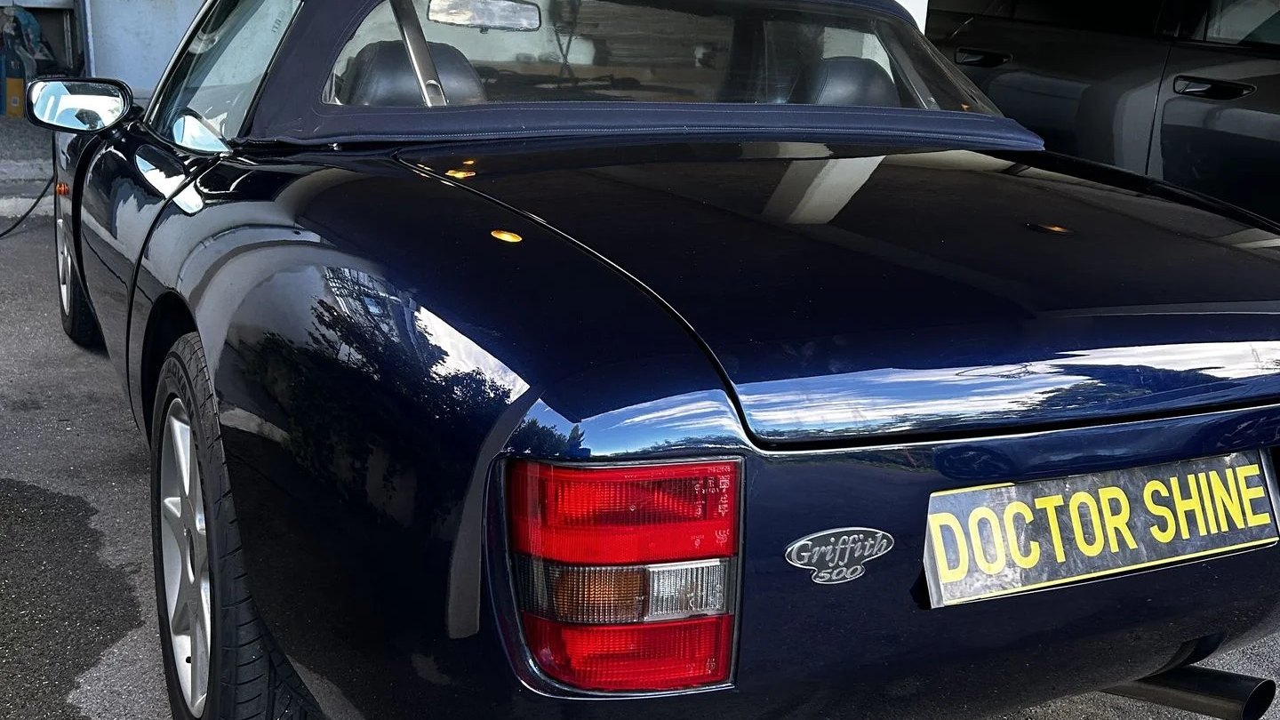 Cabriolet bleu nuit à la carrosserie lustrée avec plaque Doctor Shine, nettoyage à domicile par Doctor Shine