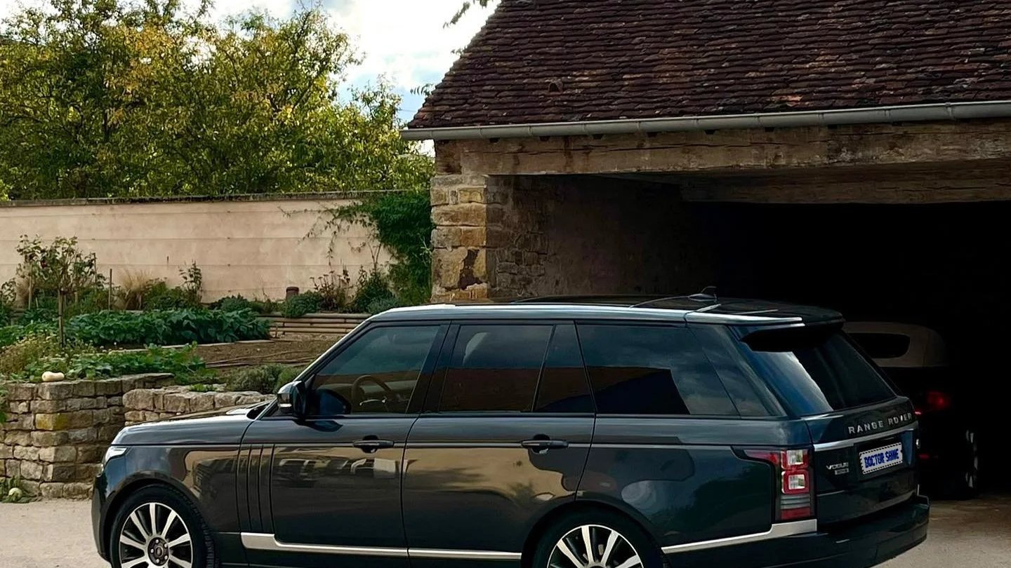 Range Rover garé devant un garage chez un client, nettoyage à domicile par Doctor Shine
